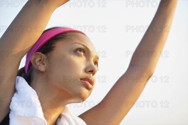 Hispanic woman stretching outdoors