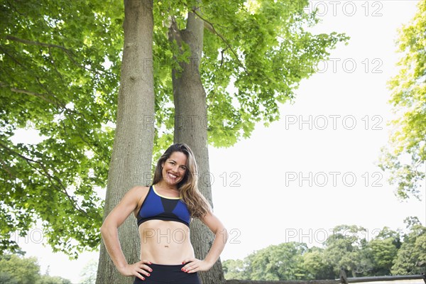 Mixed race woman standing under trees