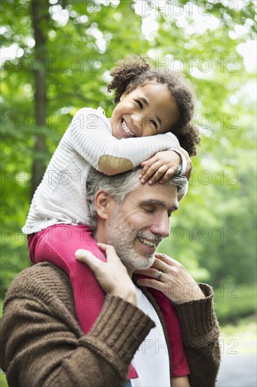 Father carrying daughter on shoulders