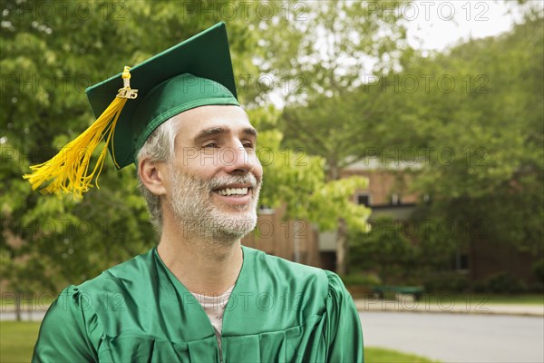 Caucasian college graduate wearing cap and gown