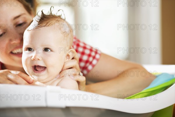 Caucasian mother bathing baby daughter