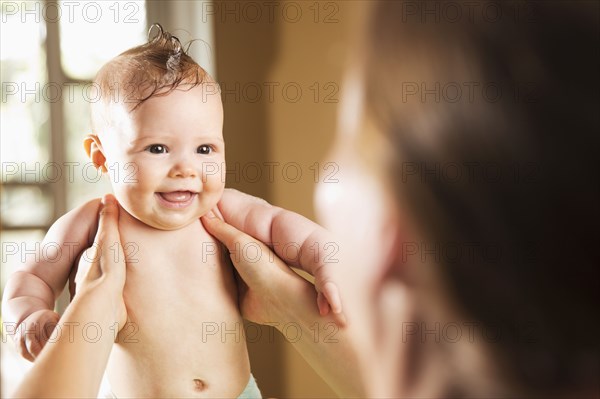 Caucasian mother bathing baby daughter