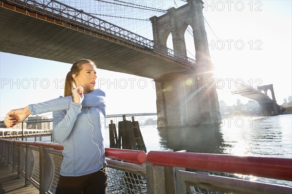 Caucasian runner stretching on waterfront