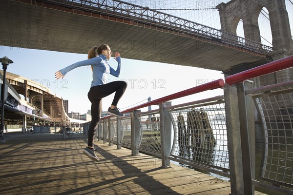 Caucasian runner stretching on waterfront