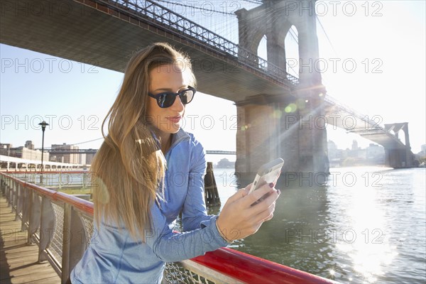 Caucasian woman using cell phone on waterfront