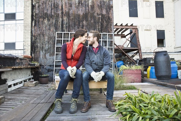 Couple sitting in urban rooftop garden