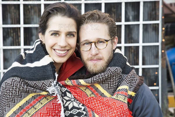 Couple wrapped in blanket outdoors