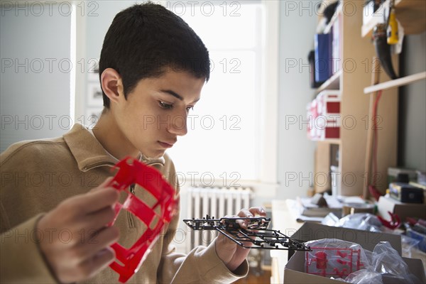 Mixed race teenage boy building model toy