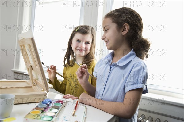 Smiling girls painting