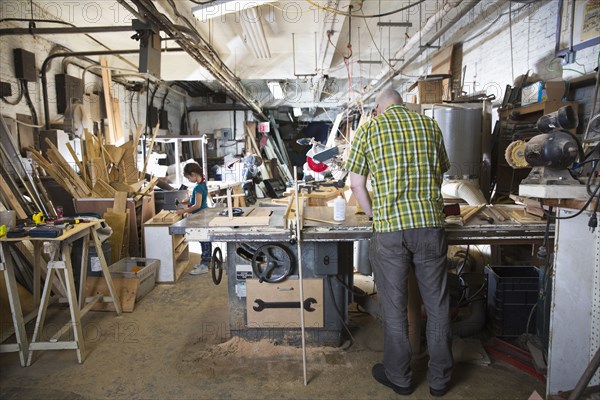 Father and daughter woodworking in workshop