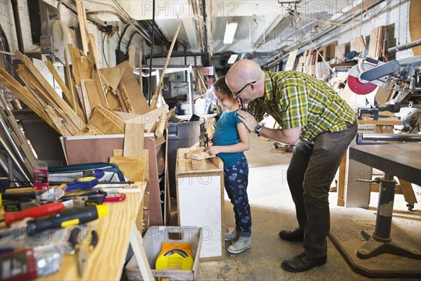 Father and daughter woodworking in workshop