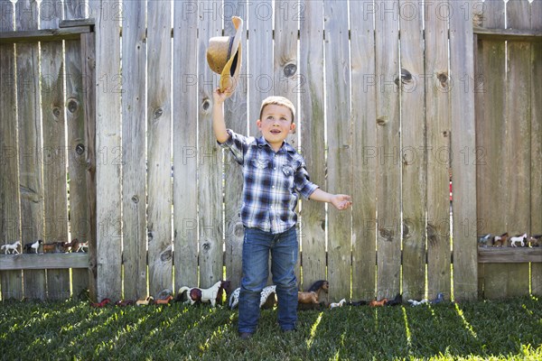 Caucasian boy waving cowboy hat