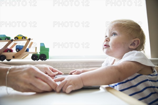 Caucasian mother helping baby girl use digital tablet