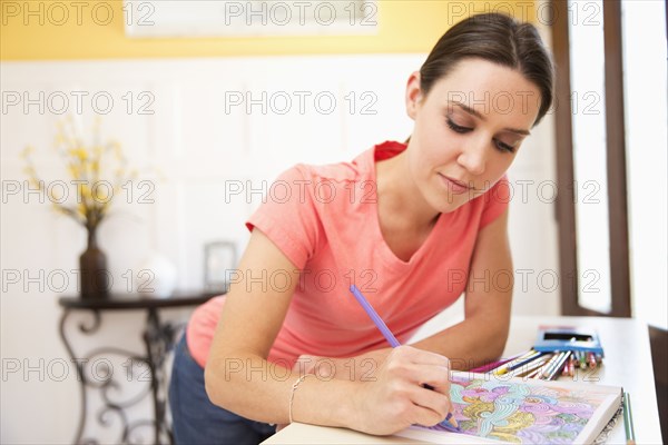 Caucasian woman drawing in coloring book