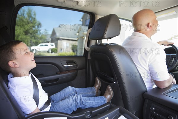 Smiling Caucasian father and son in car