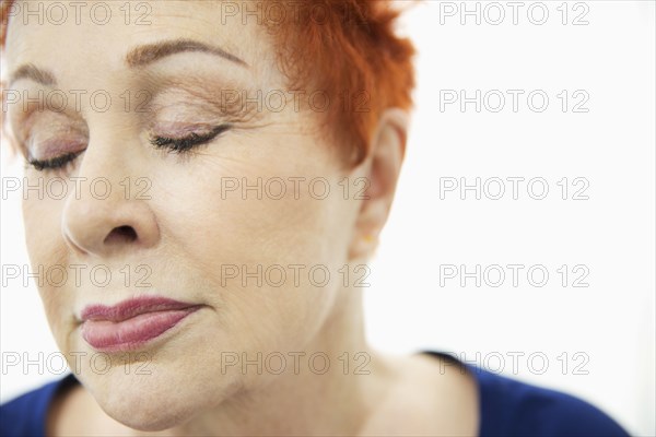 Face of older Caucasian woman with eyes closed