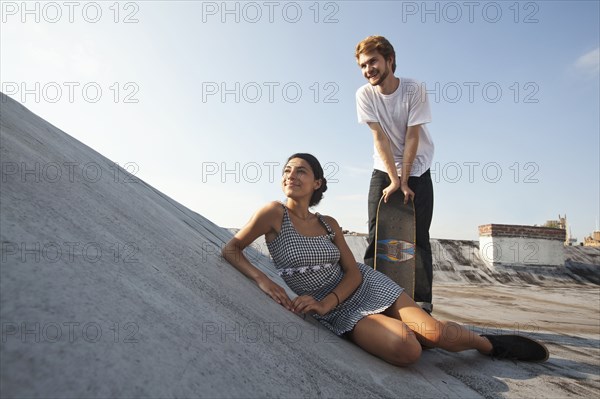 Mixed Race couple on rooftop with skateboard