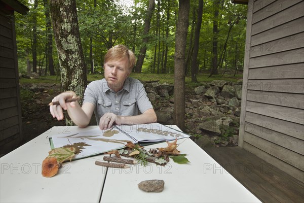 Caucasian man with nature scrapbook outdoors