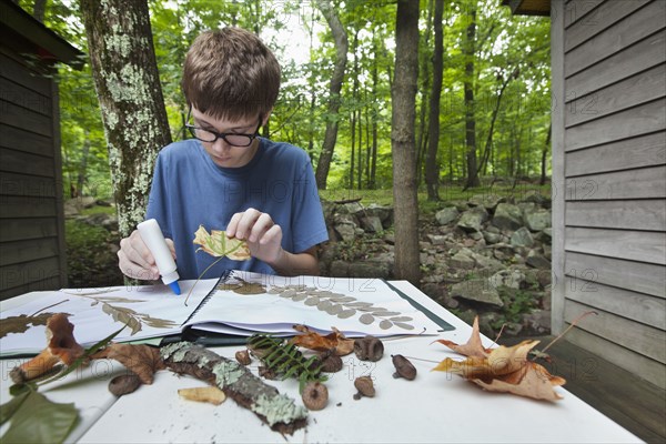 Caucasian boy with nature scrapbook outdoors