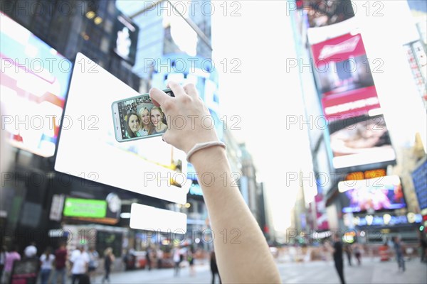 Arm of Caucasian woman posing for cell phone selfie with friends