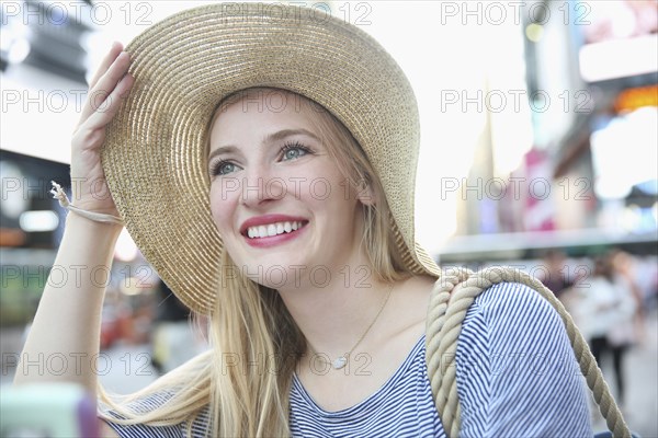 Portrait of smiling Caucasian woman wearing hat in city