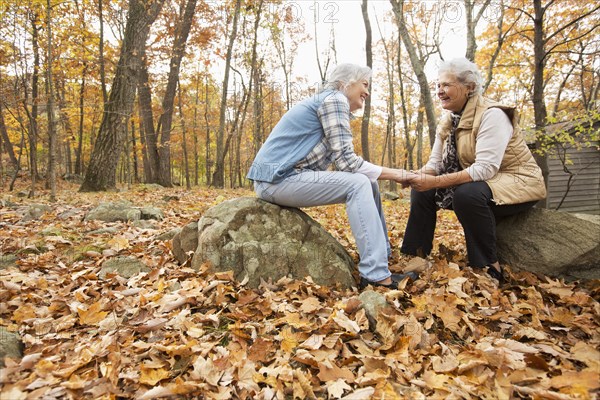 Caucasian women holding hands outdoors in autumn