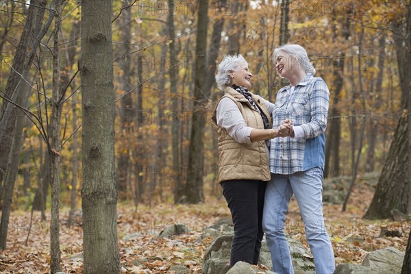 Caucasian women dancing outdoors in autumn