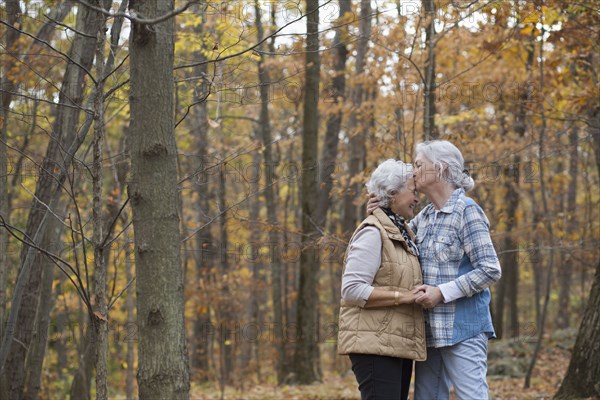 Caucasian women kissing outdoors in autumn