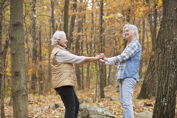 Caucasian women dancing outdoors in autumn