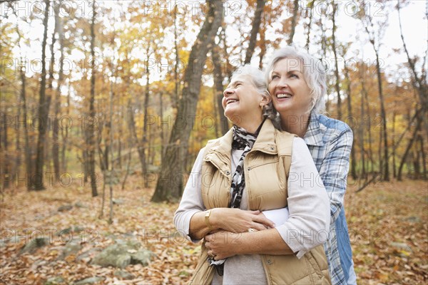 Caucasian women hugging outdoors in autumn