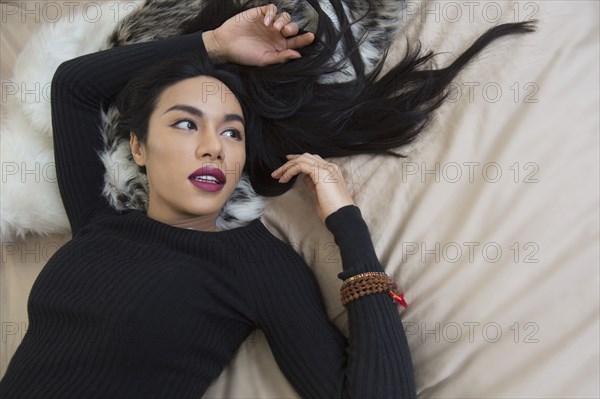 Glamorous transgender Thai woman laying on bed