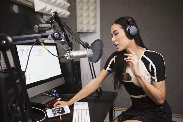 Thai transgender woman using computer and microphone