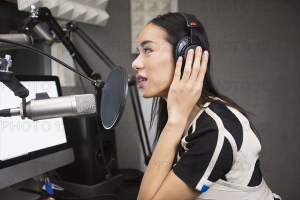 Thai transgender woman using headphones and microphone
