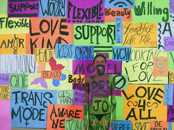 Thai transgender woman blending with message collage on wall