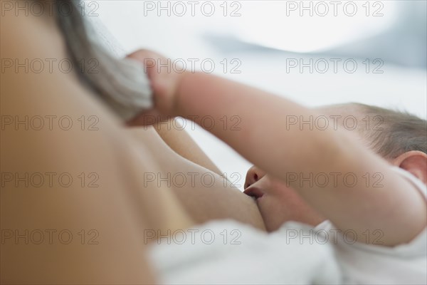 Close up of woman breast-feeding baby son