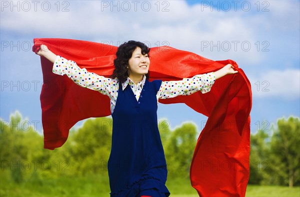 Asian woman holding blanket in wind