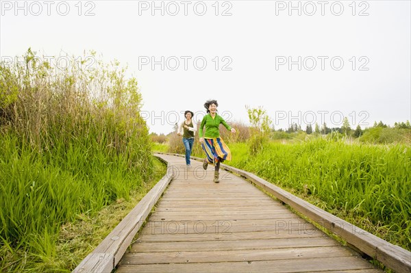 Asian couple running on wooden path