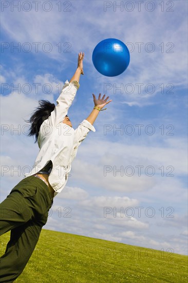 Asian man jumping for ball