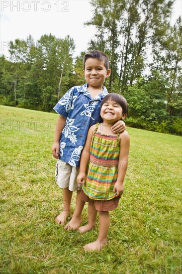 Asian siblings with bare feet outdoors