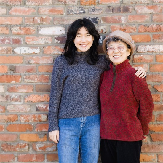 Asian mother and adult daughter hugging