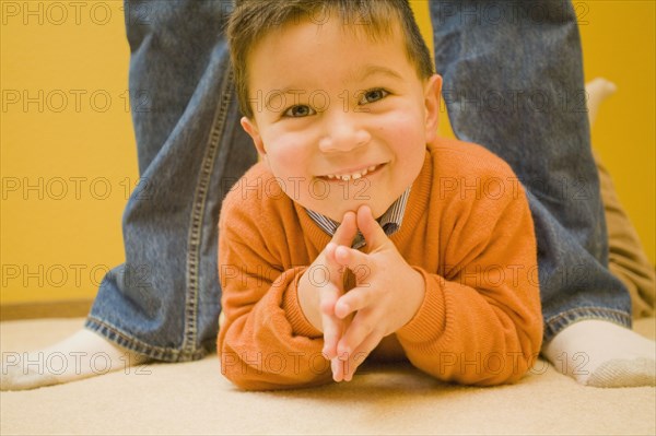 Mixed race boy laying on floor