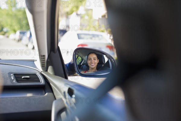 Image of Hispanic woman in car's side mirror