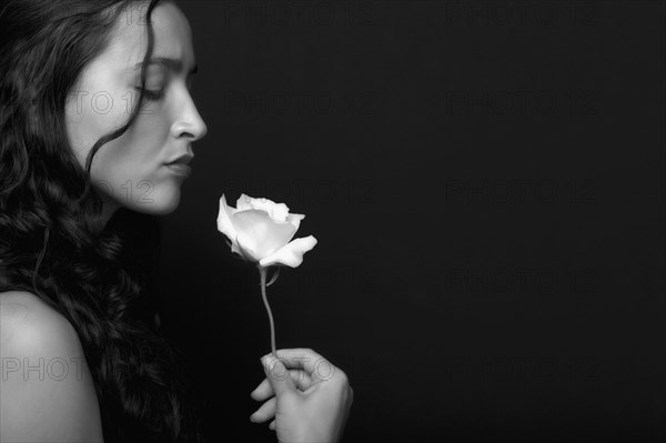 Hispanic woman smelling rose