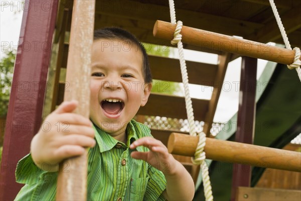 Mixed race boy playing in playground