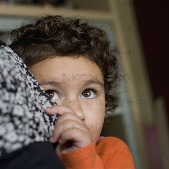 Shy mixed race boy hiding