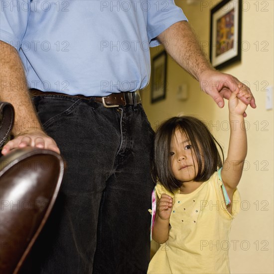 Asian girl holding father's hand