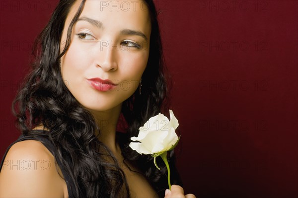 Hispanic woman posing with white rose