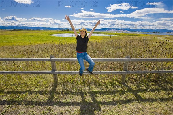 Japanese woman sitting on remote countryside field