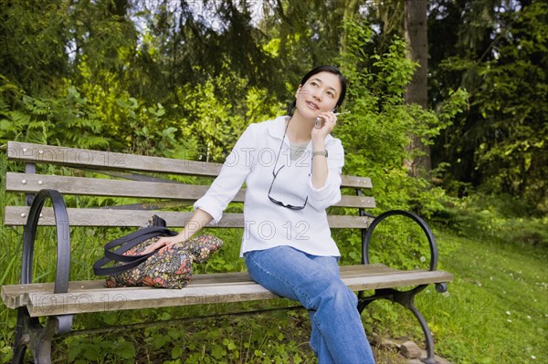 Japanese woman using cell phone in park