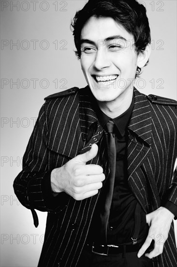 Laughing mixed race man in fashionable coat